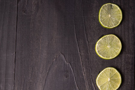 A clsoeup shot of cut limes on dark backgroundの写真素材
