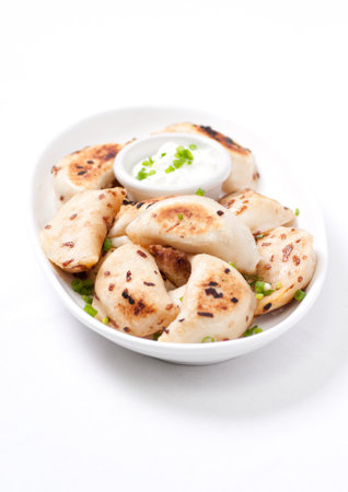 home made pierogies with sour cream and onionsの写真素材