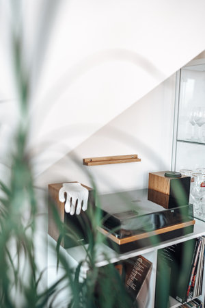 A vertical shot of a room interior with a bookshelf and a glove on the music boxの写真素材