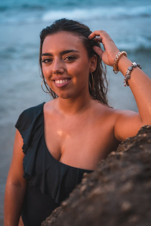 A shallow focus shot of an attractive Caucasian female in a black swimsuit posing at cameraの写真素材