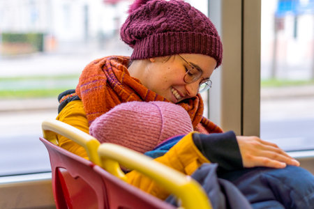 The smiling girl hugging her friend while sitting in the busの写真素材