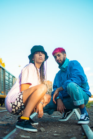 A portrait of stylish young hipster couple posing outdoors in a railway stationの写真素材