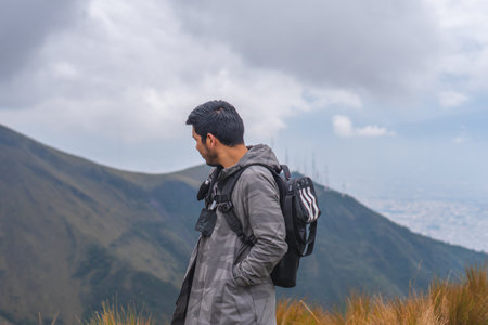 A young guy hiking in mountains and enjoying the beautiful viewの写真素材