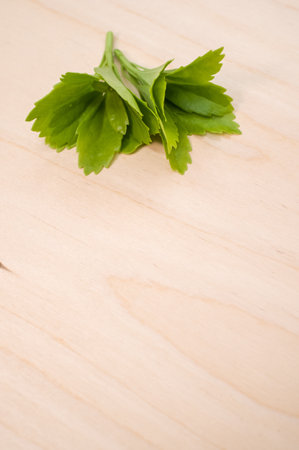 A vertical shot of fresh red clover leaves on a wicker basket on a wooden surfaceの写真素材