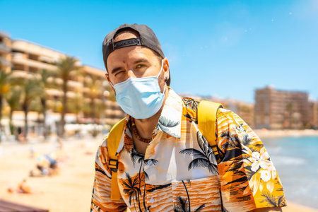 A handsome guy in a facial mask enjoying summer vacation in Cura beach in Alicante, Spainの写真素材