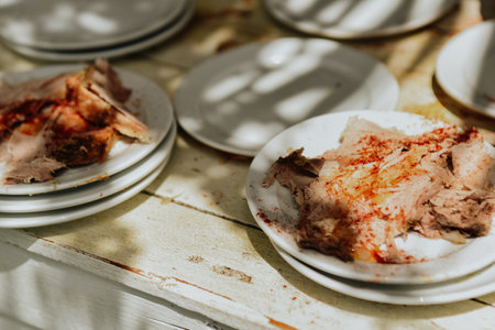 Deliciously spiced roast legs of chicken in white plates on a wooden tableの写真素材