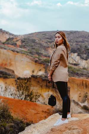 A vertical shot of a fashionable female posing on the Sabrinsky Desert stones in Colombiaの写真素材