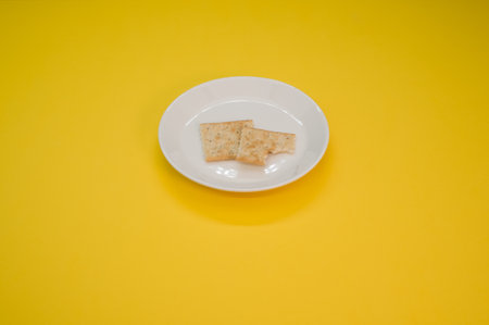 A plate with salty crackers on a yellow surfaceの写真素材