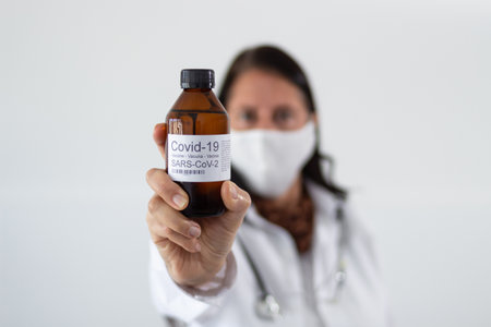 A selective focus shot of a female doctor holding a bottle of vaccine for Coronavirus Covid-19の写真素材