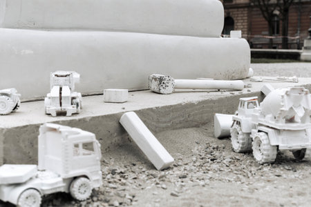 White painted toys representing construction machinery at a construction site.の写真素材