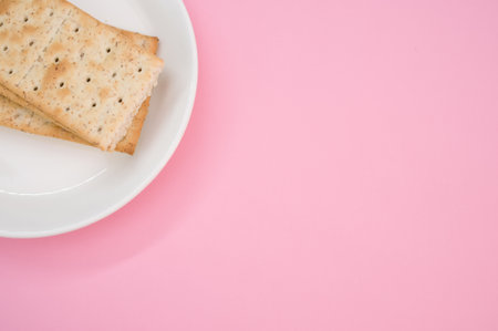 A plate with salty crackers on a pink surfaceの写真素材