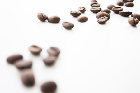 Closeup of the roasted coffee beans on the white surface - space for textの写真素材
