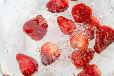 A top view of ripe red strawberries in water for washingの写真素材