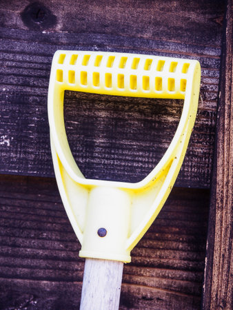A vertical shot of an old shovel on a wooden backgroundの写真素材