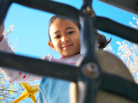 Photo of a smiling eight-year-old girl playing in a playgroundの写真素材
