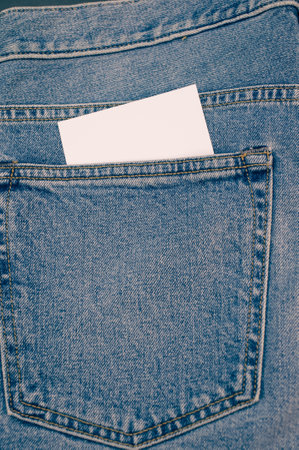 A vertical shot of a blank paper inside the pocket of a jeansの写真素材