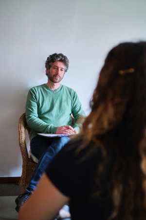 A vertical shot of a Caucasian man from Spain taking notes