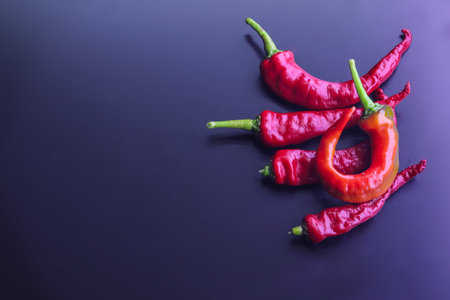 A heap of hot red chili peppers isolated on the dark backgroundの写真素材