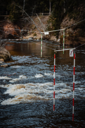 A vertical shot of the gate of whitewater slalom over the rough riverの写真素材