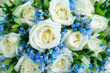 A closeup shot of a bouquet made of white roses and blue flowersの写真素材