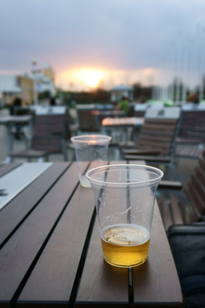 Almost empty plastic cup of beer at sunsetの写真素材