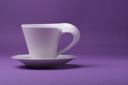 An empty porcelain white cup in the purple background;a studio shotの写真素材