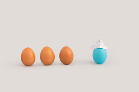 A shot of eggs, one with paper hat isolated on white backgroundの写真素材