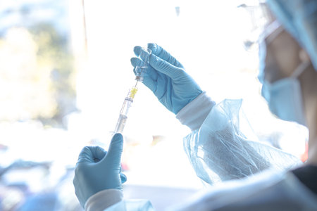 A medical worker holding the Covid-19 vaccine with a syringe
