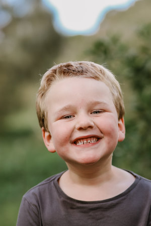 A vertical shot of a cute smiling blonde kidの写真素材