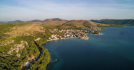 Aerial view of the mediterranean shore and above the adriatic sea, towards the Zaboric town, sunny, summer evening, in Croatiaの写真素材