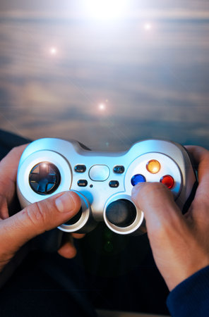 A vertical shot of a man's hands holding a video game controller.の写真素材