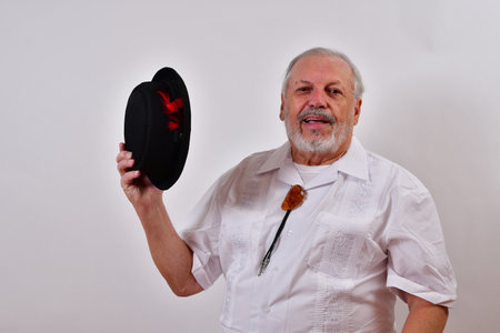 A happy senior man smiling and waving his porkpie hatの写真素材