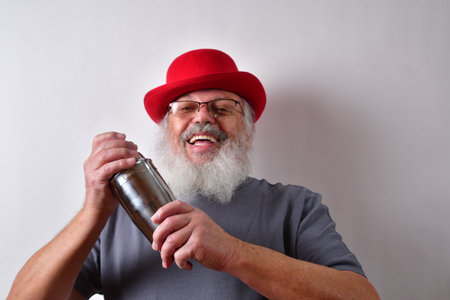 A happy old American pensioner mixing a cocktail in a shakerの写真素材