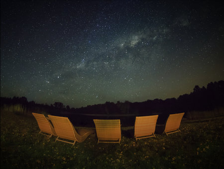 Garden chairs under starry skyの写真素材