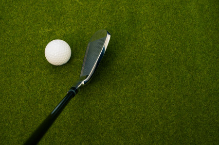 A closeup of a golf club and a ball on the grass with a copy spaceの写真素材