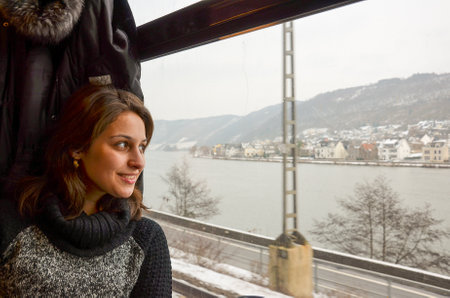 A female traveling on a train and looking out of the window