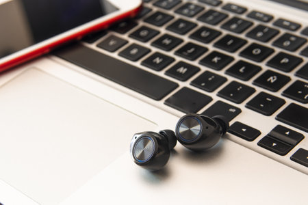 One person's workspace at home: laptop, smartphone and earphones. Conception of teleworking from home.の写真素材