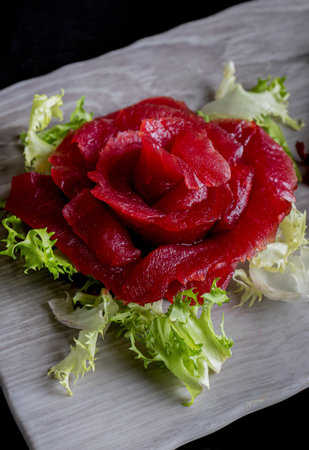 A vertical shot of a sashimi decorated in flower on a light plateの写真素材