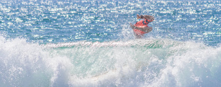 A surfer jumping into the water with splashes and waves consuming him