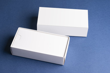 A closeup of a smartphone box with a blank cover with space for text on a blue surface