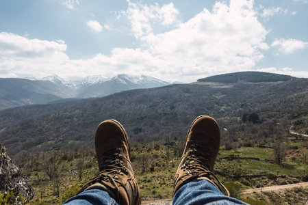 A closeup shot of hiker boots against a beautiful landscapeの写真素材
