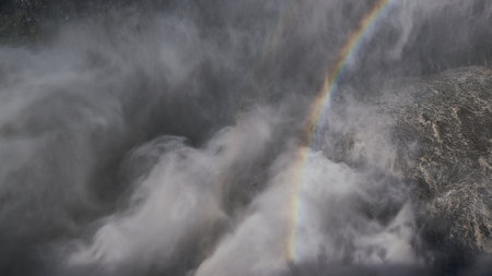 An aerial shot of the earth with clouds and a rainbow seen in the foregroundの写真素材
