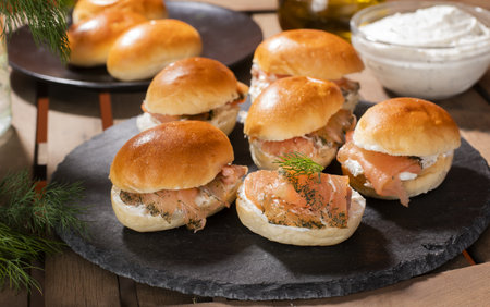 Delicious fresh burgers with smoked salmons served on a black stoneboaの写真素材