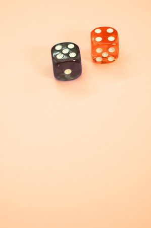 A vertical shot of a red and lack dice on an orange background with space for your text - gamin...