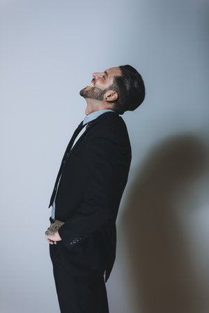 A vertical shot of an attractive male in a suit laughingの写真素材