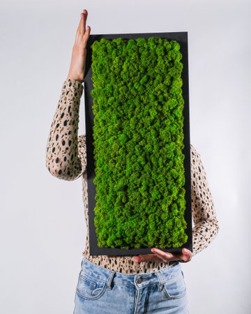 A vertical shot of a woman holding a deck with green plants growing on it
