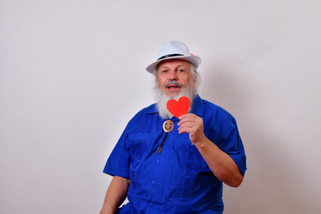 A mature gentleman with a white fedora hat, blue guayabera shirt, and bolo tie celebrating...