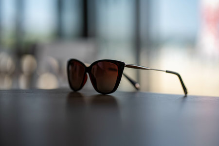 A closeup shot of brown wayfarer style sunglasses on a wooden tableの写真素材
