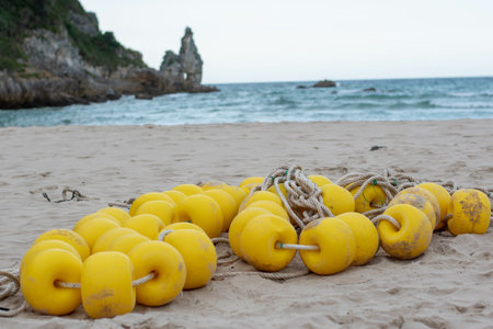 A closeup shot of a yellow buoyancy string on a beach