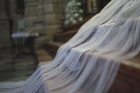 A white bridal veil on the stairs of the churchの写真素材